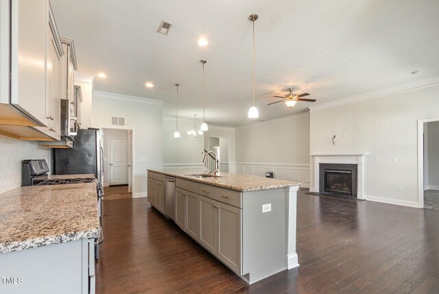 kitchen featuring a glass covered fireplace, visible vents, stainless steel appliances, and a sink