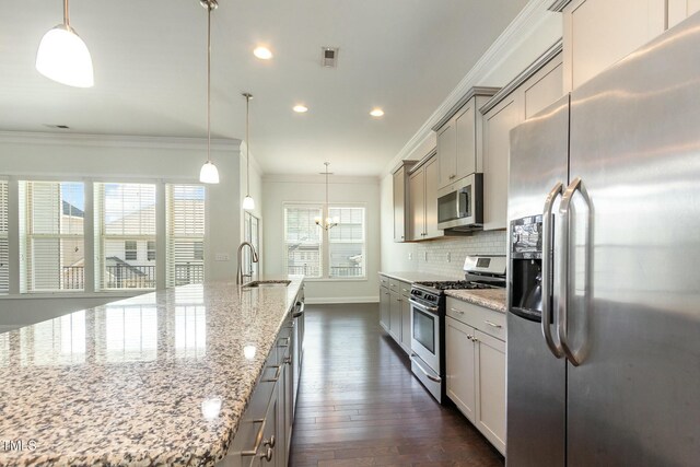 kitchen with tasteful backsplash, a sink, ornamental molding, stainless steel appliances, and dark wood-style flooring