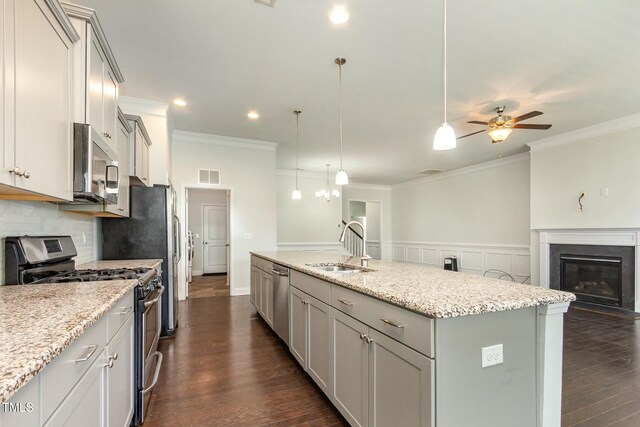 kitchen with visible vents, a sink, dark wood finished floors, stainless steel appliances, and a kitchen island with sink