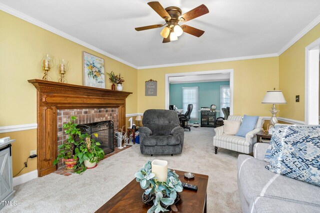 living room with carpet flooring, ceiling fan, crown molding, and a brick fireplace