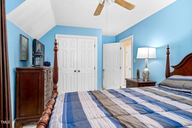 bedroom with a textured ceiling, a closet, lofted ceiling, and ceiling fan