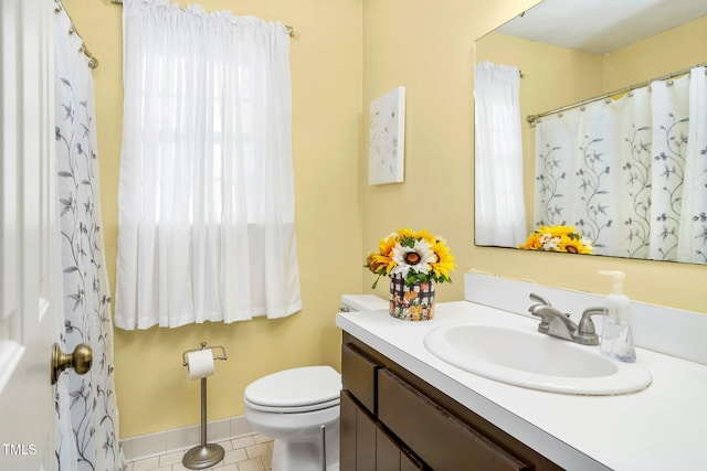 bathroom with tile patterned flooring, vanity, and toilet