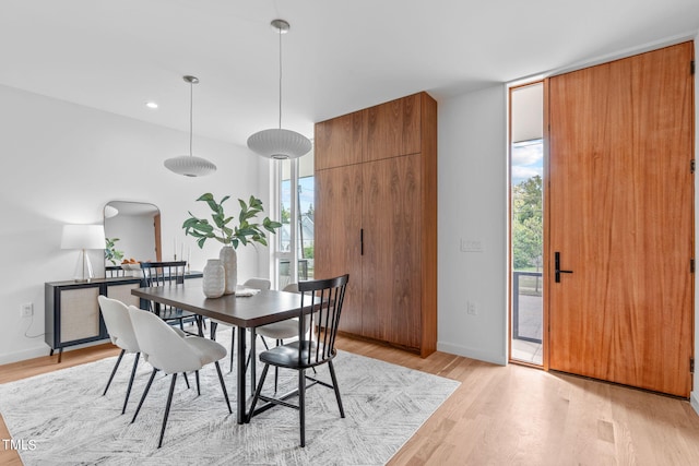 dining area with light wood-type flooring and a healthy amount of sunlight