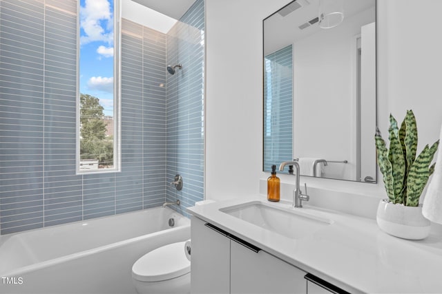 full bathroom featuring vanity, toilet, and tiled shower / bath combo