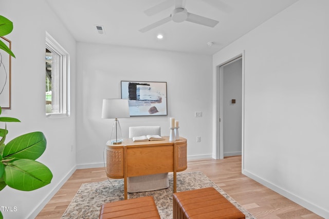 home office with light wood-type flooring and ceiling fan