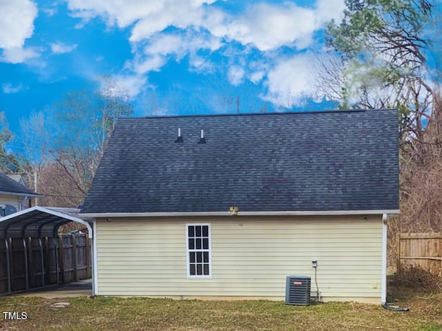 rear view of property featuring central AC, a carport, and a yard