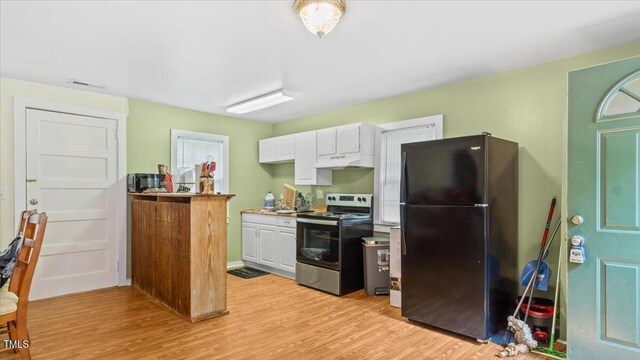 kitchen featuring white cabinets, black fridge, electric stove, and light wood-type flooring