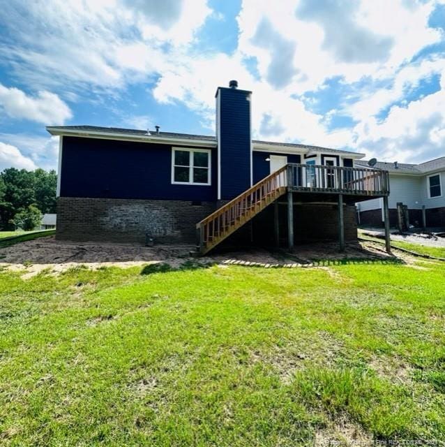 rear view of house featuring a deck and a lawn