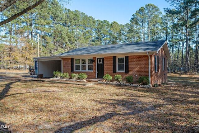 ranch-style home featuring a carport and a front lawn