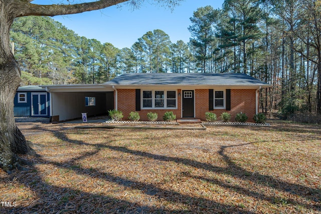 ranch-style house featuring a front yard and a carport