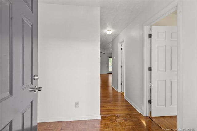 hall featuring a textured ceiling