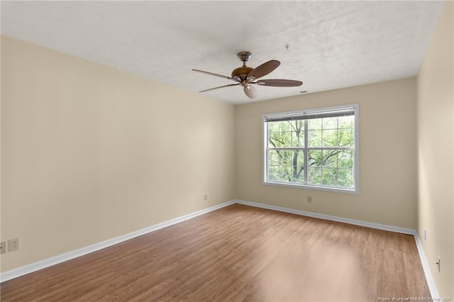 empty room with ceiling fan, light hardwood / wood-style floors, and a textured ceiling