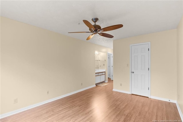 empty room with ceiling fan and light hardwood / wood-style floors