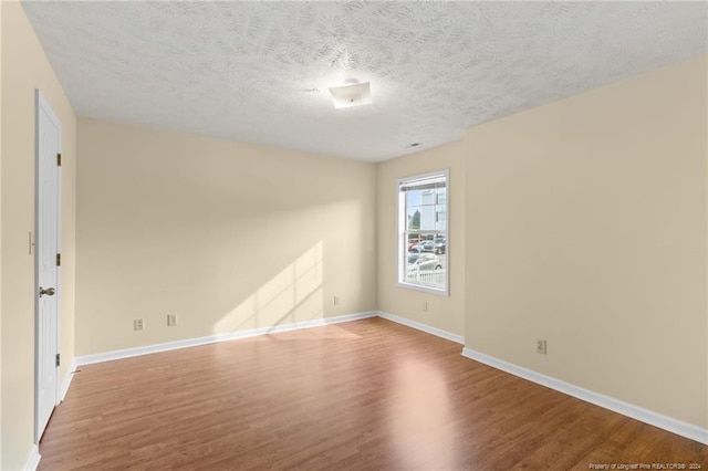 spare room with wood-type flooring and a textured ceiling