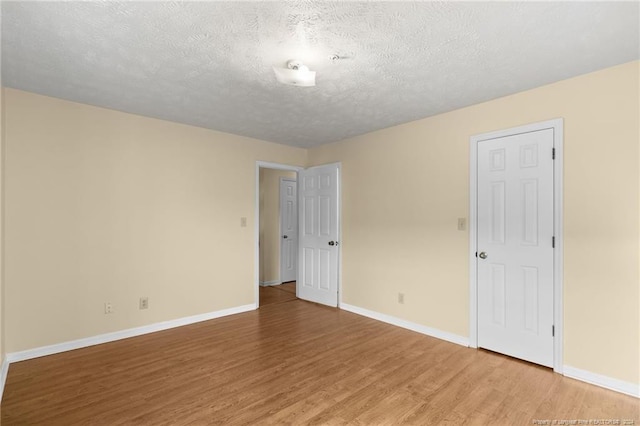 unfurnished room featuring a textured ceiling and hardwood / wood-style flooring