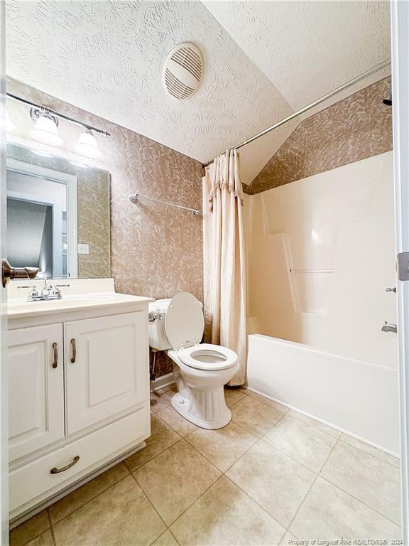 full bathroom with a textured ceiling, vaulted ceiling, toilet, vanity, and shower / tub combo