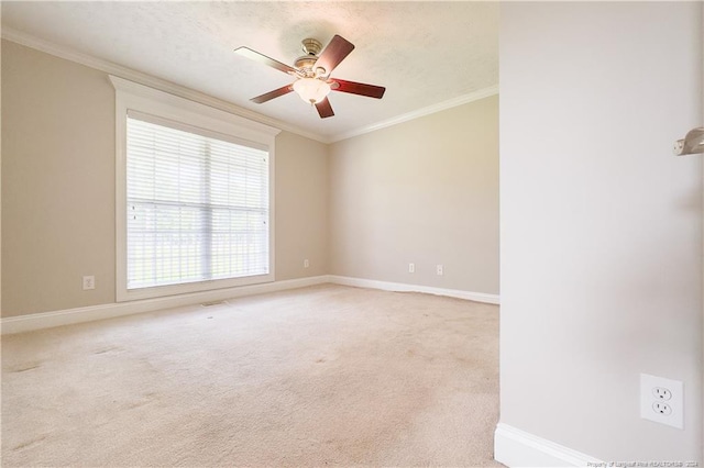 carpeted spare room with ceiling fan and crown molding