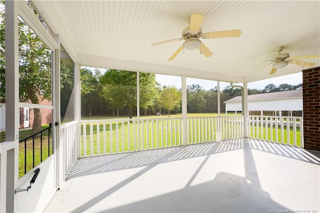 unfurnished sunroom featuring ceiling fan