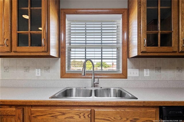 4419 Cameron Rd, Hope Mills, NC 28348 - kitchen with brown cabinets, light countertops, glass insert cabinets, and tasteful backsplash