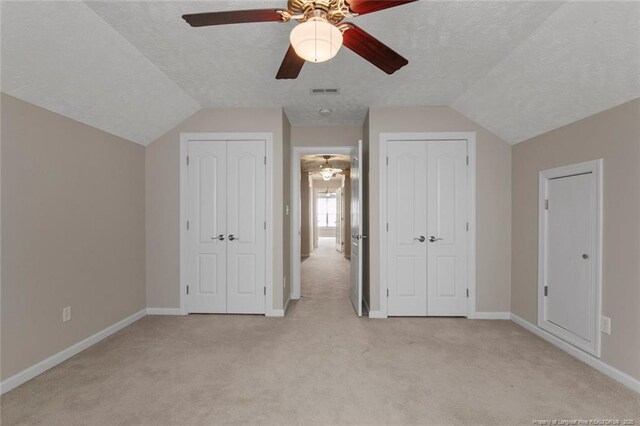 4419 Cameron Rd, Hope Mills, NC 28348 - unfurnished bedroom featuring two closets, light carpet, vaulted ceiling, a textured ceiling, and ceiling fan