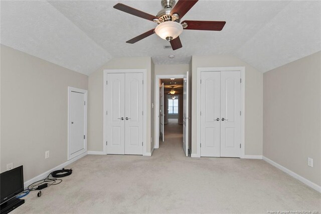 4419 Cameron Rd, Hope Mills, NC 28348 - unfurnished bedroom featuring multiple closets, vaulted ceiling, carpet, and a ceiling fan