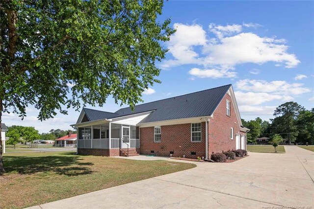 4419 Cameron Rd, Hope Mills, NC 28348 - back of house featuring a sunroom, concrete driveway, brick siding, crawl space, and a yard