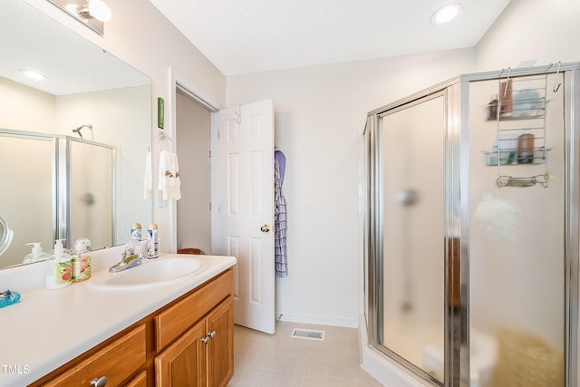 bathroom featuring vanity and a shower with door