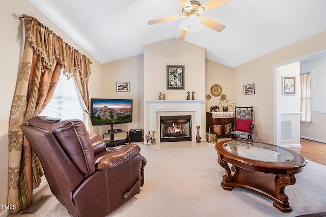 carpeted living room with ceiling fan and lofted ceiling