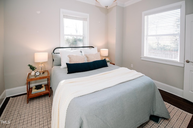 bedroom featuring multiple windows, crown molding, and dark hardwood / wood-style floors