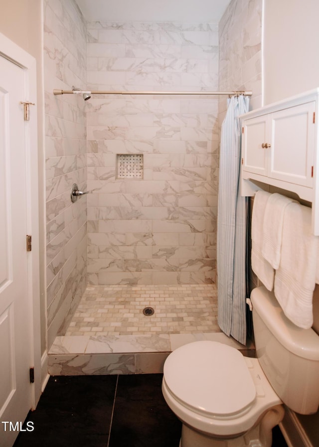 bathroom with curtained shower, tile patterned flooring, and toilet