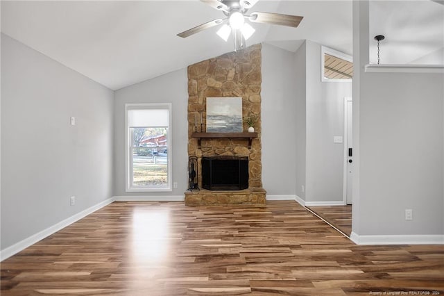 unfurnished living room with a stone fireplace, ceiling fan, vaulted ceiling, and hardwood / wood-style flooring