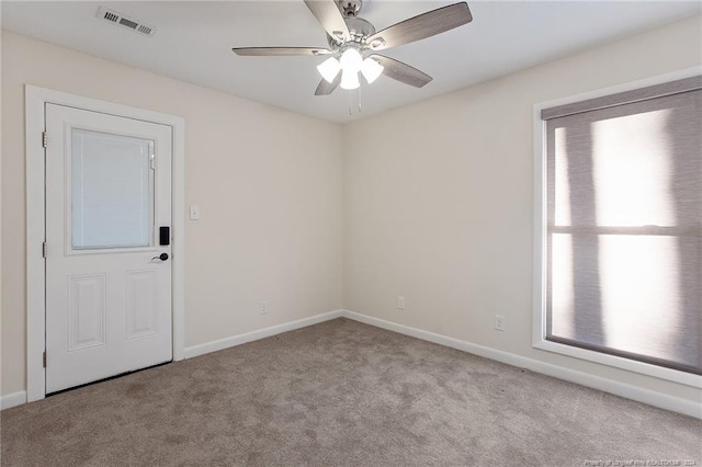 unfurnished room with ceiling fan, light colored carpet, and a healthy amount of sunlight