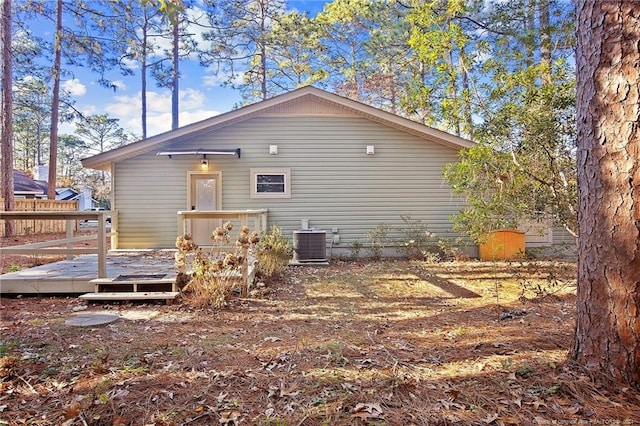 back of property with central AC unit and a wooden deck