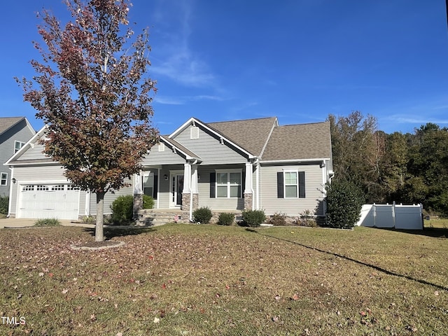 view of front of house featuring a front lawn, a porch, and a garage