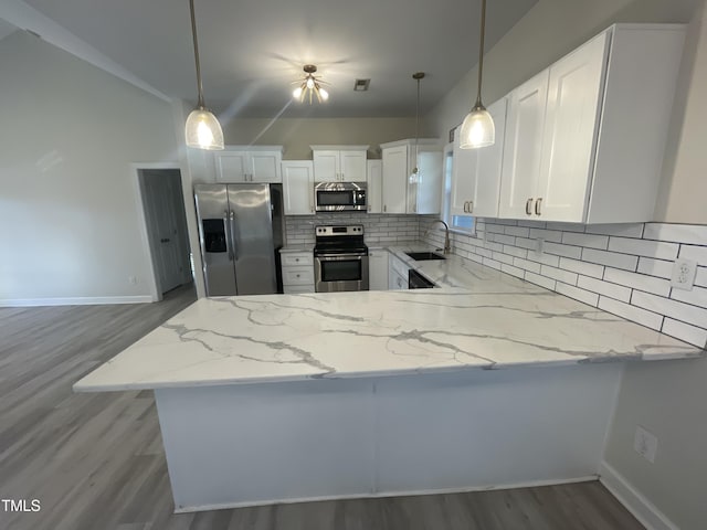 kitchen featuring white cabinets, stainless steel appliances, and hanging light fixtures