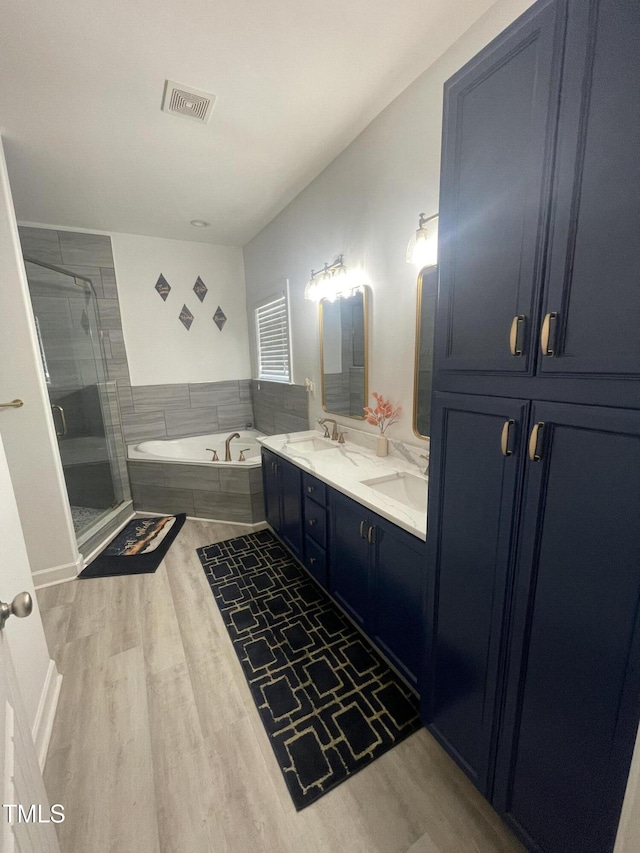 bathroom with separate shower and tub, vanity, and wood-type flooring