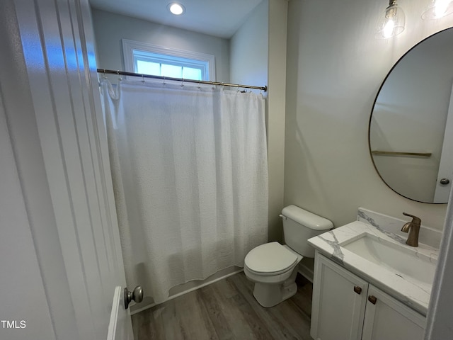 bathroom with toilet, vanity, and hardwood / wood-style flooring