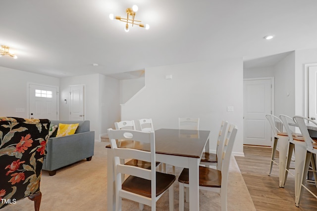 dining area featuring light hardwood / wood-style floors and an inviting chandelier