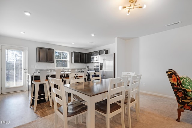 dining space featuring a chandelier and light hardwood / wood-style flooring