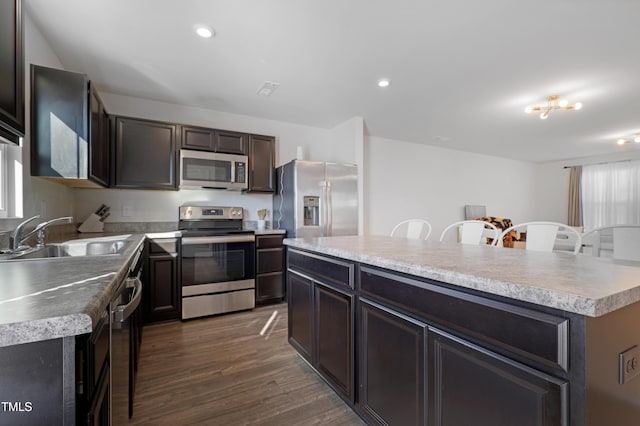 80 Bella Vita Way, Angier, NC 27501 - kitchen featuring stainless steel appliances, a sink, dark wood finished floors, a center island, and light countertops