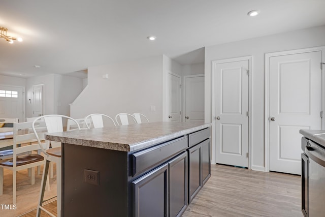 80 Bella Vita Way, Angier, NC 27501 - kitchen featuring a breakfast bar, light wood finished floors, a kitchen island, recessed lighting, and light countertops