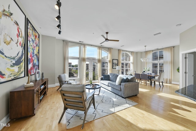 living room featuring light hardwood / wood-style flooring, french doors, ceiling fan, and track lighting