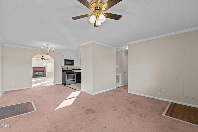 unfurnished living room featuring a textured ceiling, ceiling fan, crown molding, and light carpet