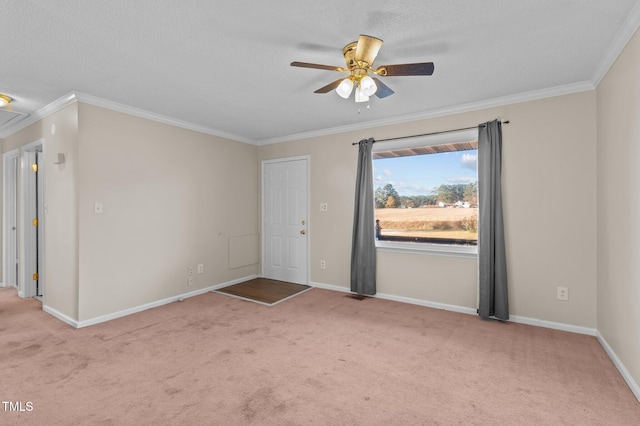 empty room featuring a textured ceiling, light colored carpet, ceiling fan, and ornamental molding