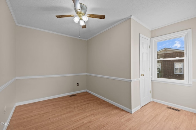 unfurnished room with a textured ceiling, light wood-type flooring, and crown molding