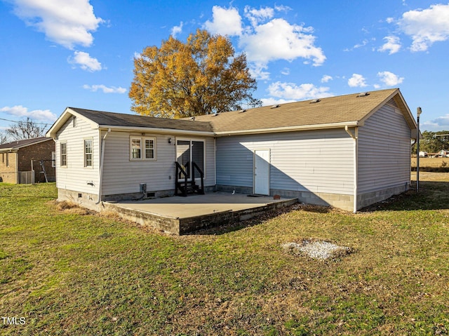 rear view of house featuring a lawn and a patio