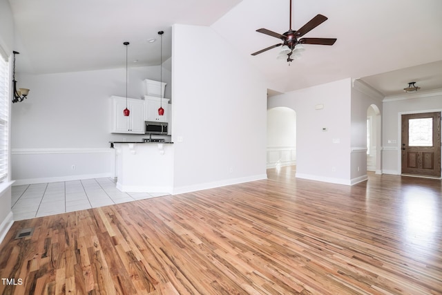 unfurnished living room featuring high vaulted ceiling, light hardwood / wood-style flooring, and ceiling fan