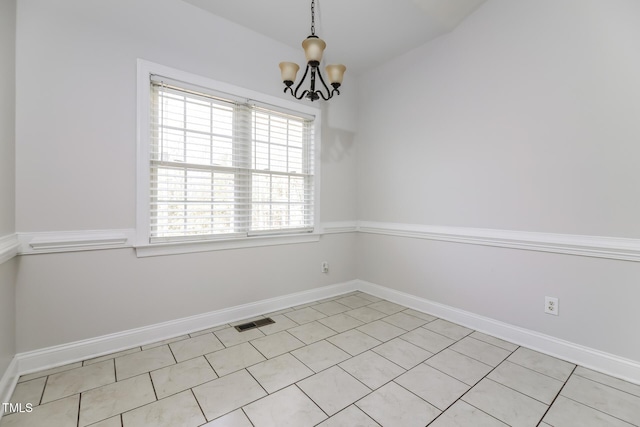 empty room featuring light tile patterned floors and an inviting chandelier