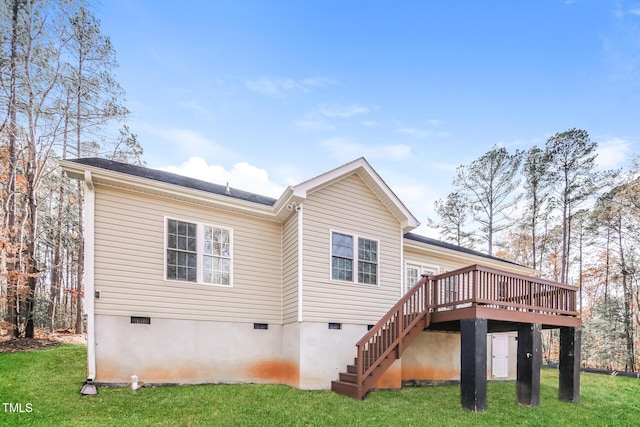 rear view of property featuring a lawn and a wooden deck