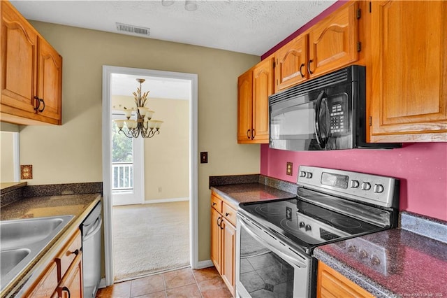 kitchen with sink, a textured ceiling, appliances with stainless steel finishes, a notable chandelier, and light tile patterned flooring